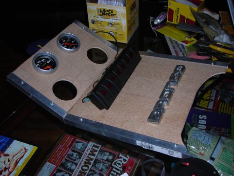 1995 Ford Bronco - A custom dashboard panel two gauges, a switch bank, and a chrome 'BRONCO' emblem, likely for a vehicle modification project.