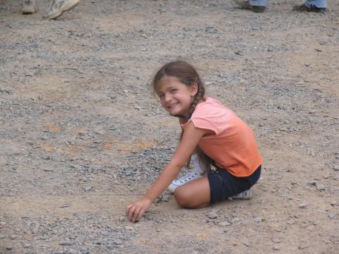 1995 Ford C-350 (Centurion Conversions) - A young girl with braided hair smiles while playing on a gravel surface.