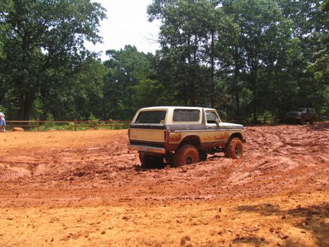 1995 Ford C-350 (Centurion Conversions) - A 1978 Ford Bronco navigates a muddy off-road course, with another vehicle in the distance.