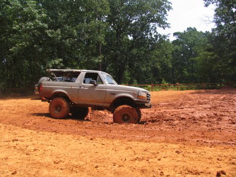 1995 Ford C-350 (Centurion Conversions) - A 1995 Ford Bronco is stuck in thick mud off-road.