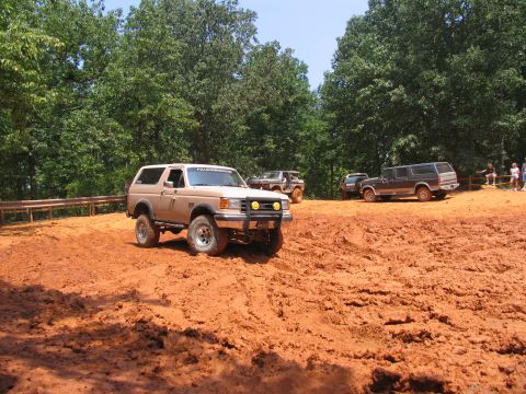 1995 Ford C-350 (Centurion Conversions) - Several off-road vehicles navigate a dirt track during an event.