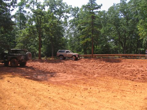 1995 Ford C-350 (Centurion Conversions) - Two off-road vehicles navigate a muddy terrain during an event in July 2006.