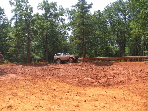1995 Ford C-350 (Centurion Conversions) - Ford Bronco navigating a muddy off-road course during an event.