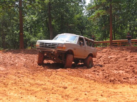 1995 Ford C-350 (Centurion Conversions) - Ford Bronco navigating a muddy off-road course with lifted suspension.