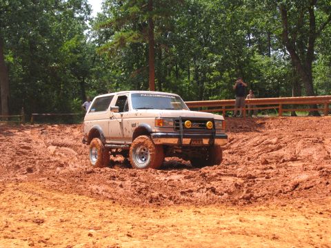 1995 Ford C-350 (Centurion Conversions) - Ford Bronco tackles a muddy trail during an off-road event.