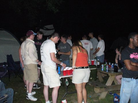 1991 Ford Probe - People are socializing around a picnic table at an outdoor gathering.
