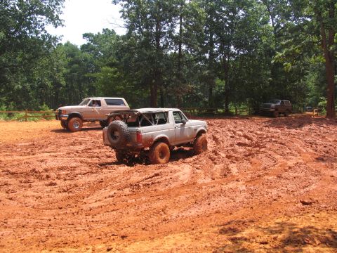 1995 Ford C-350 (Centurion Conversions) - Multiple off-road vehicles navigate a muddy terrain during an event in July 2006.