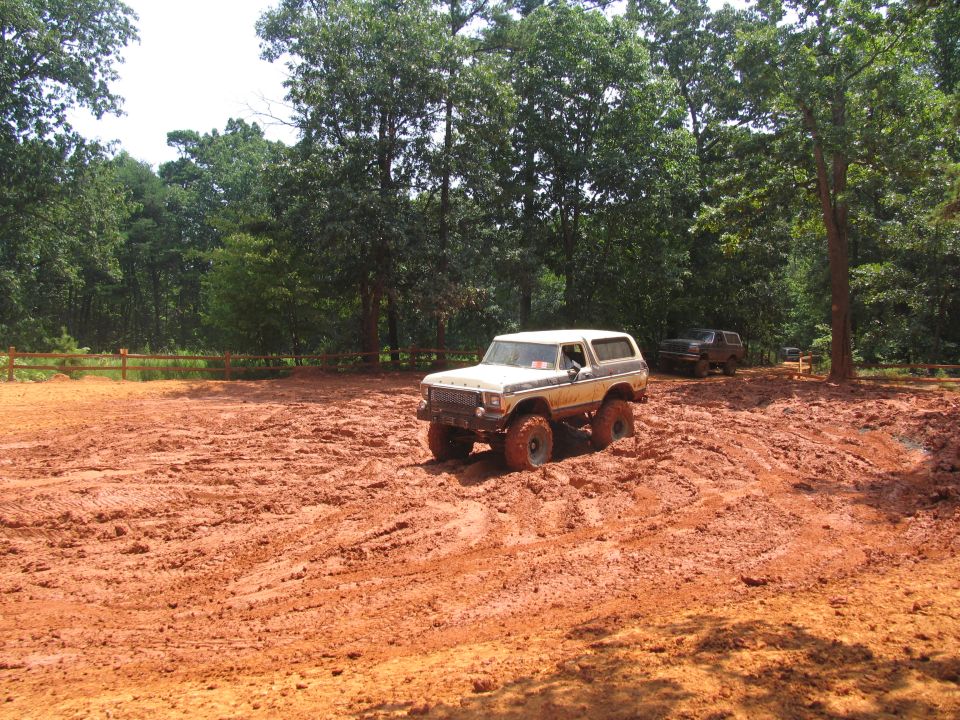 1978 Ford Bronco off-roading in mud with another SUV behind it