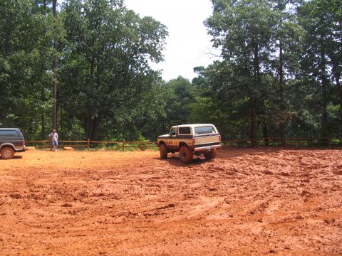 1995 Ford C-350 (Centurion Conversions) - Two SUVs are parked in a muddy, wooded area.
