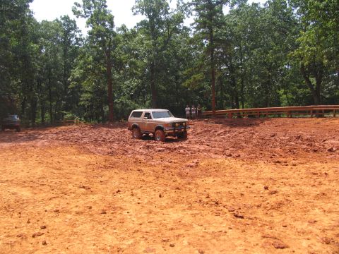 1995 Ford C-350 (Centurion Conversions) - A Ford Bronco navigates a muddy terrain with spectators watching nearby.