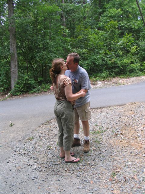1995 Ford C-350 (Centurion Conversions) - A couple shares a kiss on a wooded road.