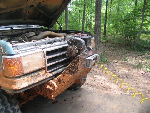 1995 Ford C-350 (Centurion Conversions) - Mud-covered Ford F-Series truck with hood open, a winch and air hose connected to the front bumper.