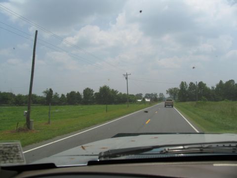 1995 Ford C-350 (Centurion Conversions) - Driving down a country road with fields and trees lining the asphalt.