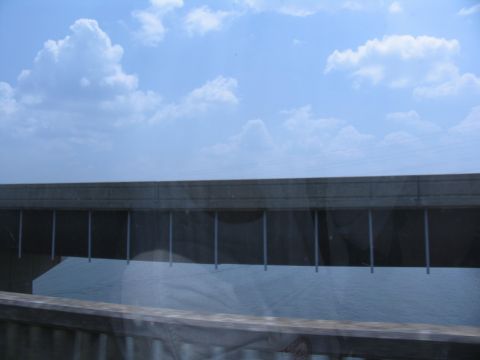 1995 Ford C-350 (Centurion Conversions) - A view from a vehicle shows a bridge structure over a body of water on a partly cloudy day.