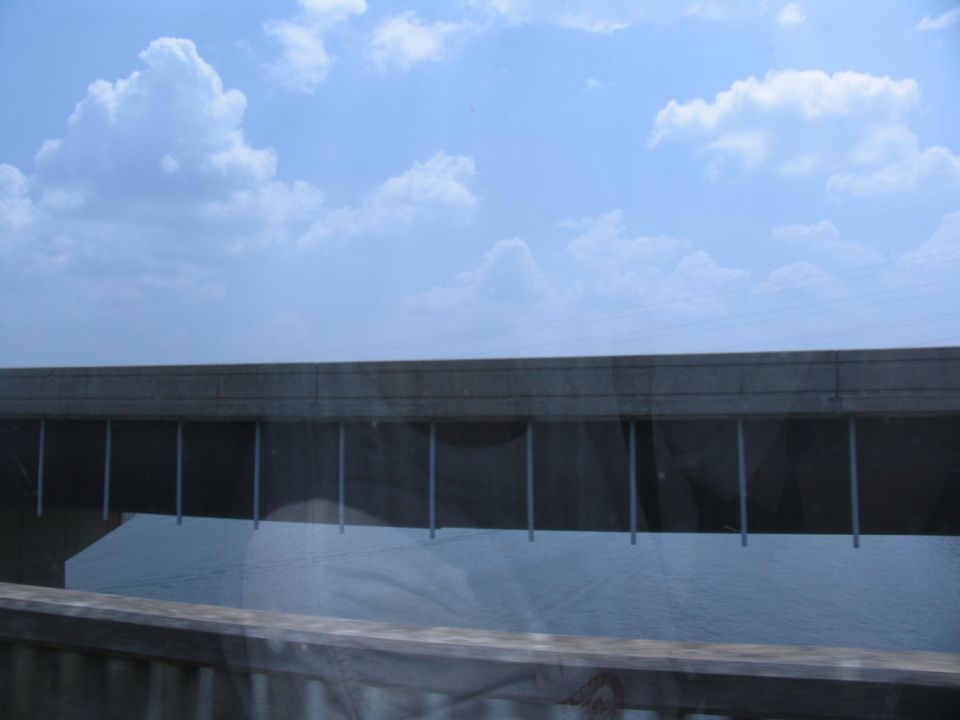 View of a bridge over water under a cloudy blue sky