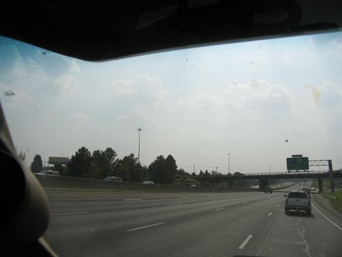 1995 Ford C-350 (Centurion Conversions) - A truck travels down a highway under an overhead sign indicating an exit.