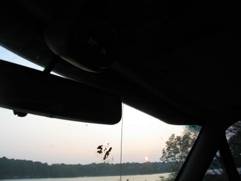 1995 Ford C-350 (Centurion Conversions) - View from inside a vehicle, showing a digital display and a lake at sunset.