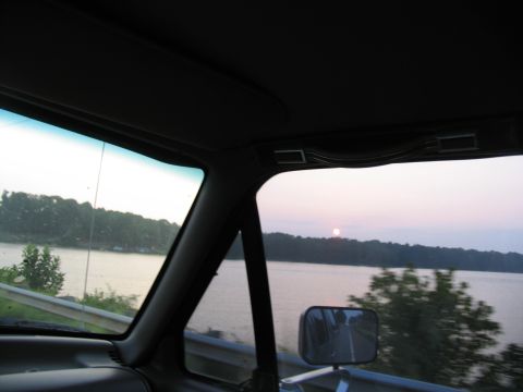 1995 Ford C-350 (Centurion Conversions) - Driving by a lake at sunset, looking out the passenger side window.