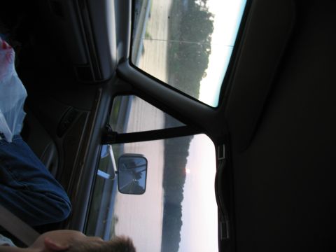 1995 Ford C-350 (Centurion Conversions) - View from inside a vehicle, looking out the window past the side mirror.