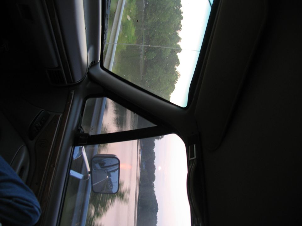 1995 Ford C-350 (Centurion Conversions) interior showing dashboard, door panel, and side mirror reflecting a road
