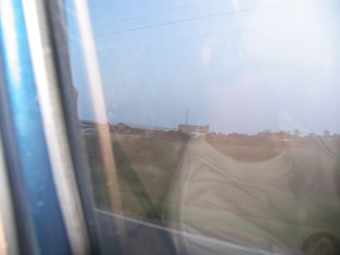 1995 Ford C-350 (Centurion Conversions) - A blurry reflection of a person is seen in a vehicle's window, obscuring the outside landscape.