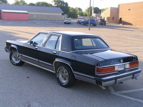 1989 Mercury Grand Marquis - Rear view of a black 1989 Mercury Grand Marquis parked in an asphalt lot.