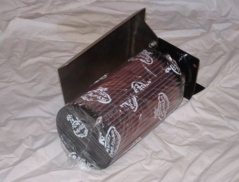 1998 Ford Crown Victoria - plastic-wrapped cone air filter on a stainless steel heat-shield bracket photographed at an angle on white cloth.