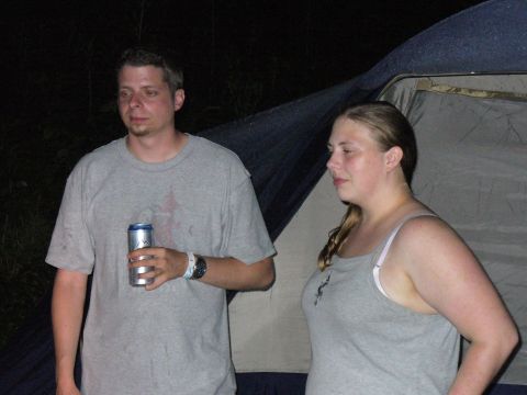 1991 Ford Probe - Two people are standing outside a tent at night, with one holding a beverage can.