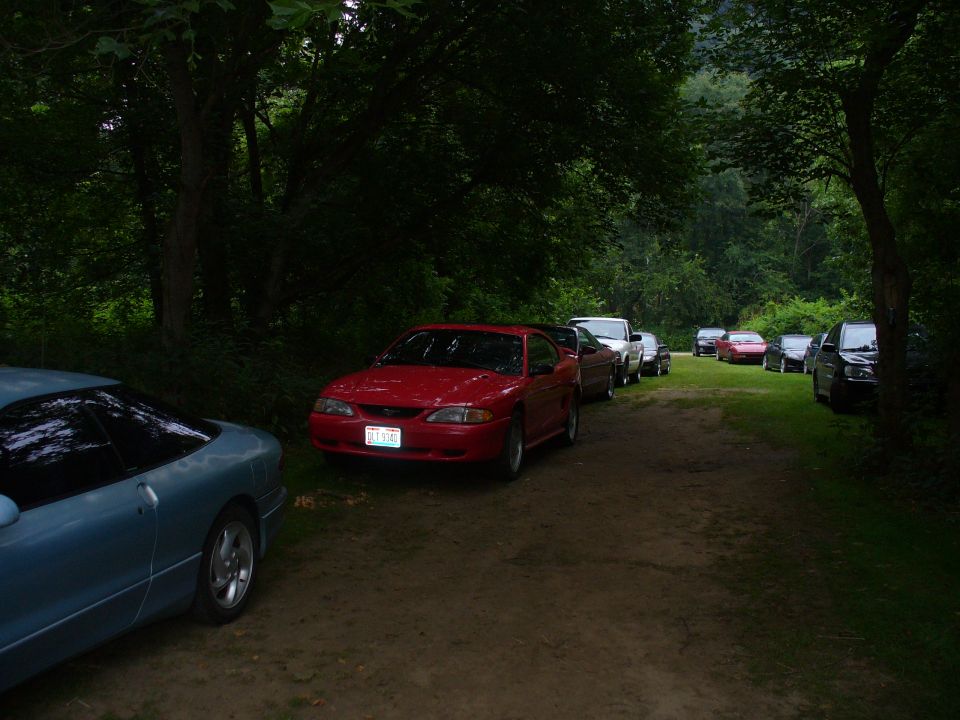Blue coupe and red 1991 Ford Probe parked on dirt road