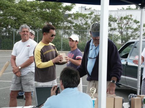 2001 Mercury Grand Marquis - People gather around a table at an outdoor event, with a dark green sedan visible in the background.