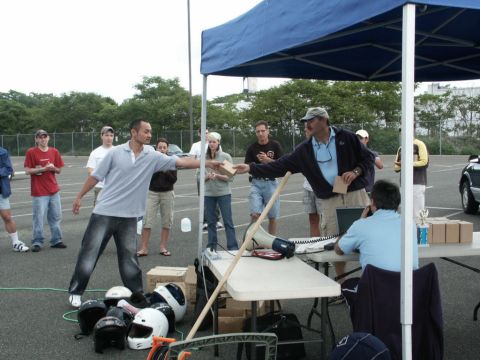 2001 Mercury Grand Marquis - An outdoor event with people, tables, helmets, and a blue tent is in progress.