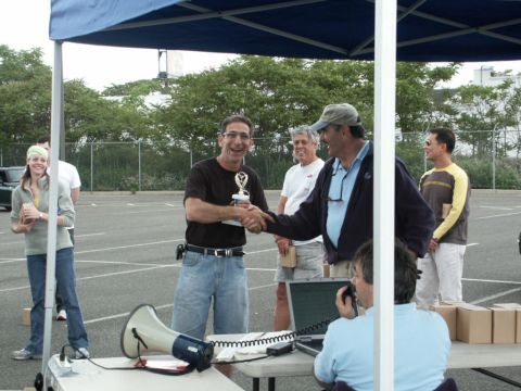 2001 Mercury Grand Marquis - A man is handed a trophy by another man, with several people observing the event.