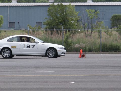 2001 Mercury Grand Marquis - White coupe with racing numbers on the side is on a track next to an orange cone.