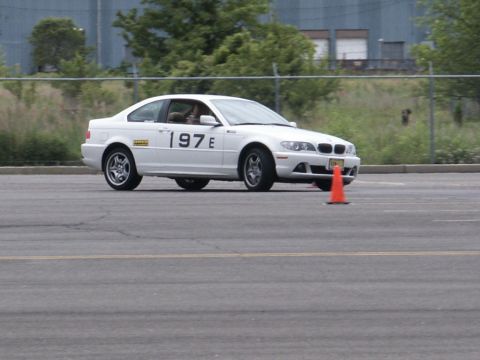 2001 Mercury Grand Marquis - A white coupe navigates a track, marked with racing numbers and an orange cone.