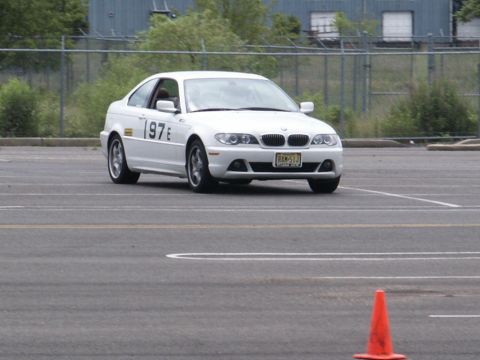 2001 Mercury Grand Marquis - A white BMW coupe with racing numbers is seen on a paved track with orange cones.