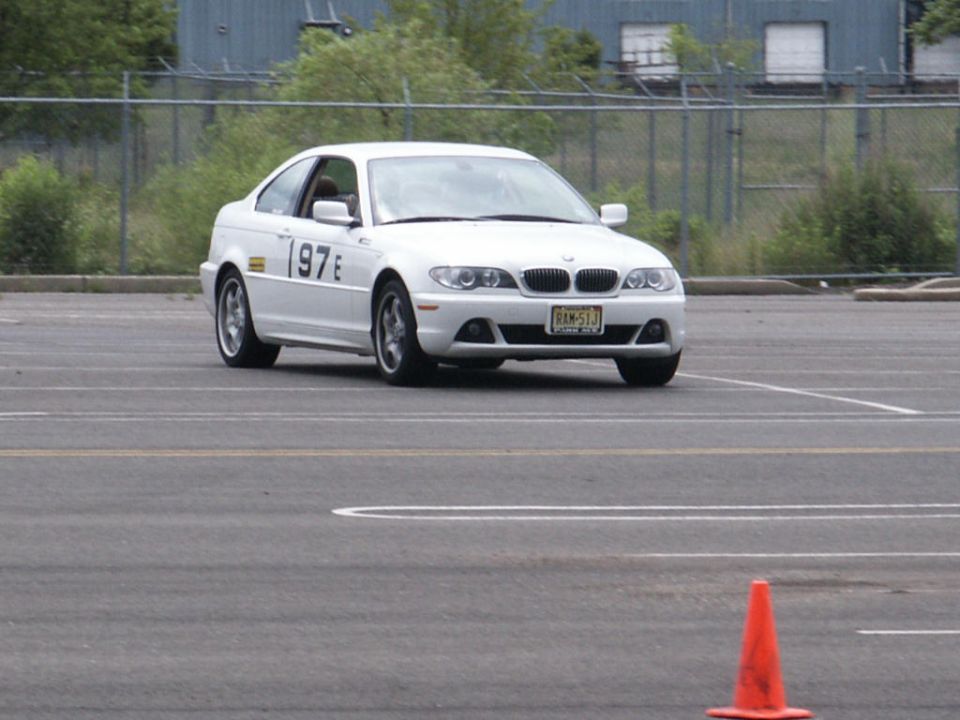 White BMW coupe with number 197 on the door, driving on a track