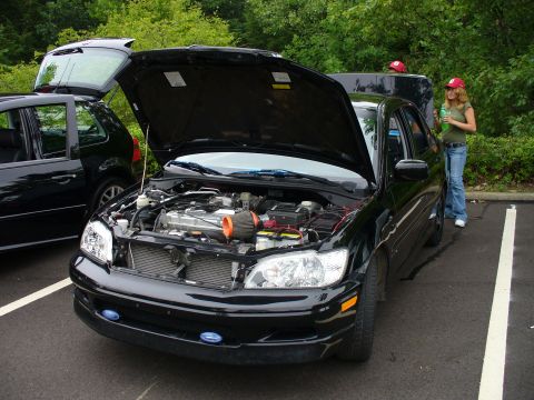 1991 Ford Probe - A black sedan is parked with its hood open, revealing the engine compartment.