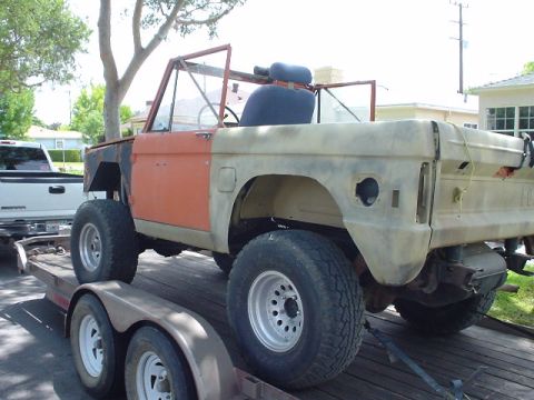 1977 Ford Bronco - This 1977 Ford Bronco is being transported on a trailer, showing its orange front fender and beige rear body.