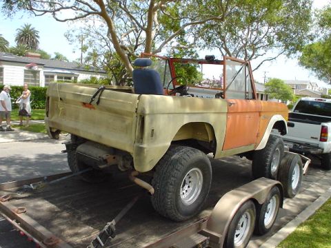 1977 Ford Bronco - A 1977 Ford Bronco is being transported on a trailer, accompanied by a white pickup truck.