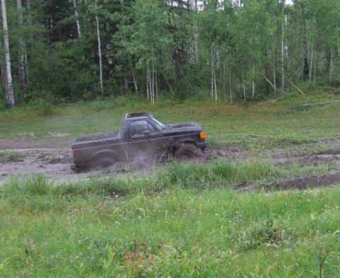 1988 Ford Bronco - Pickup truck stuck in mud during an off-road event.