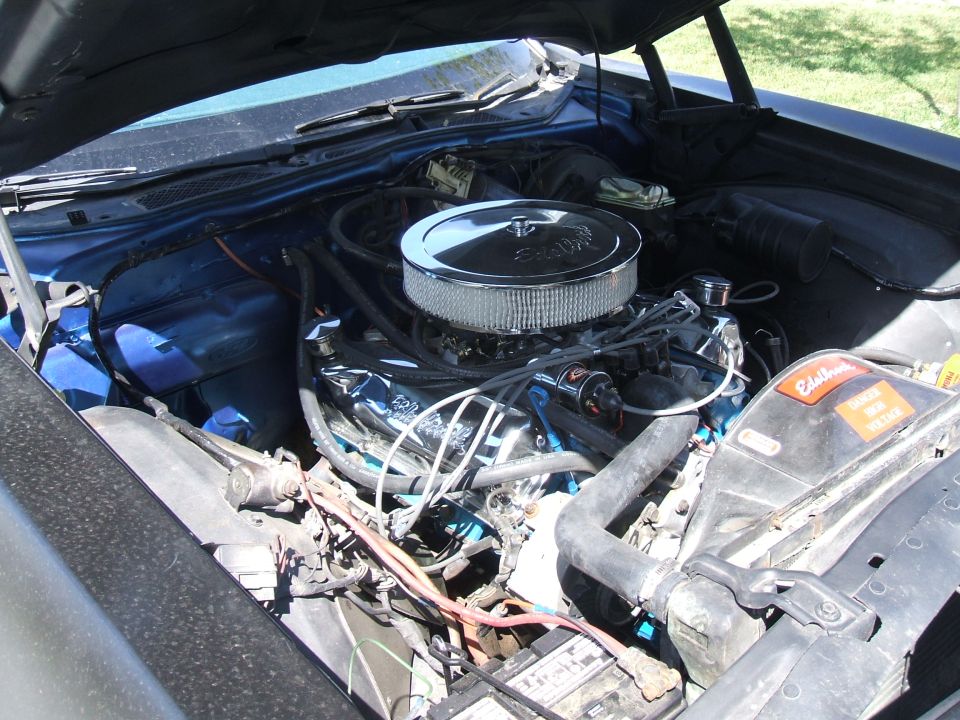 Classic Ford V8 engine bay with chrome round air cleaner and blue inner fenders