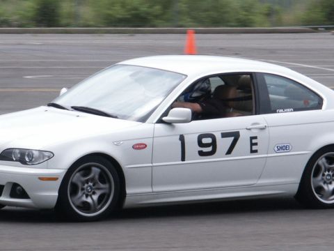 2001 Mercury Grand Marquis - A white BMW coupe, marked with racing numbers, navigates a track during a performance driving event.