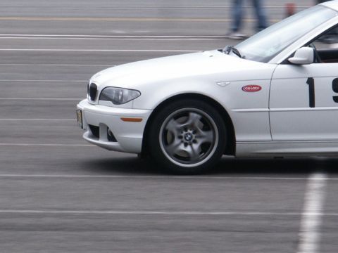 2001 Mercury Grand Marquis - A white BMW sedan with racing decals is captured in motion on a track.