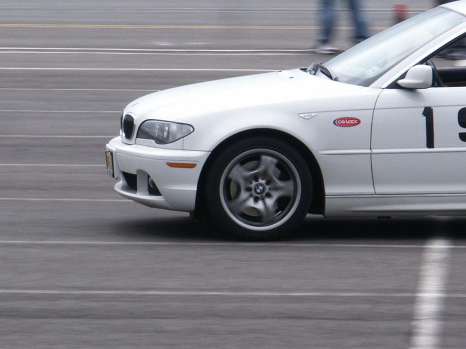 White BMW sedan with racing number 19 and a 'Co-Loce' sticker on the fender