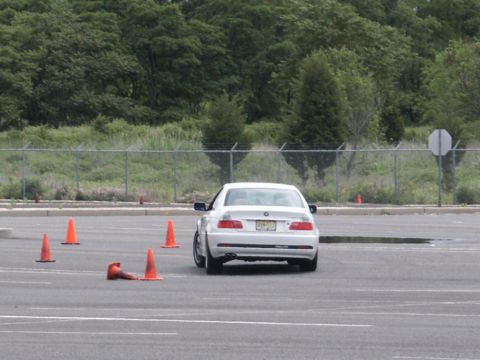2001 Mercury Grand Marquis - A white sedan navigates a course marked by orange traffic cones on a cloudy day.