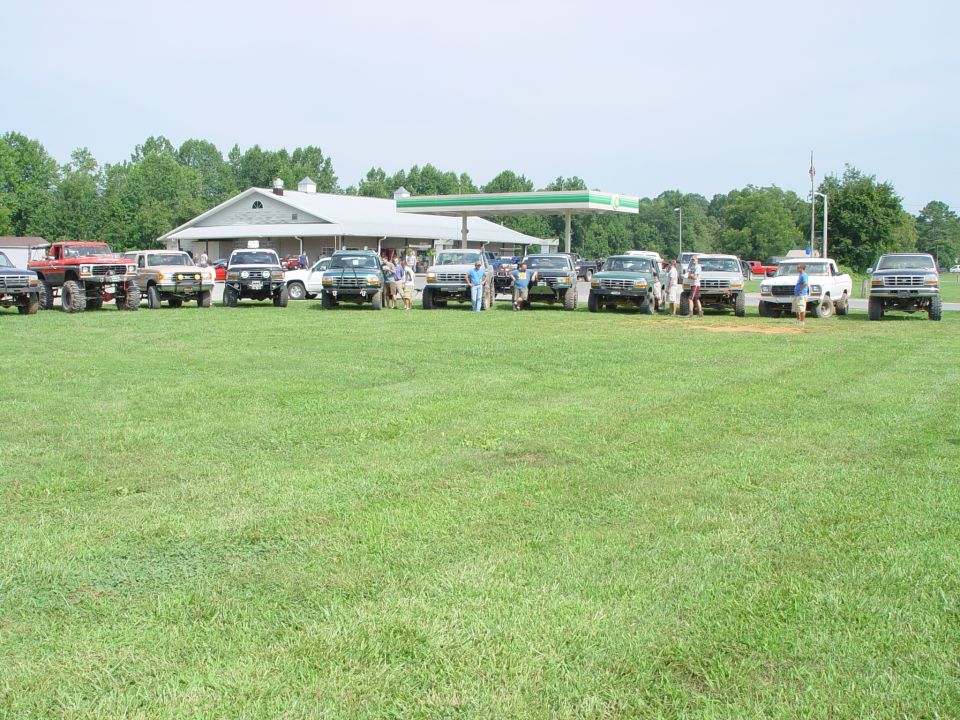 Group of SUVs and trucks parked on grass