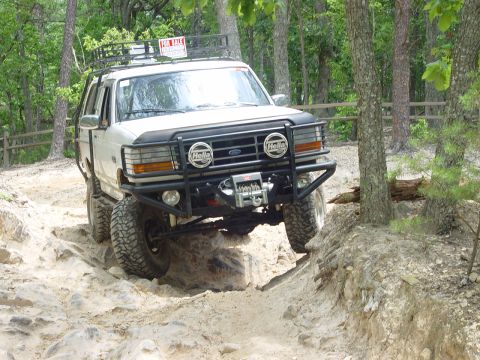 1996 Ford Bronco - This 1996 Ford Bronco is navigating a challenging rocky trail, with a 'FOR SALE' sign visible on its roof rack.