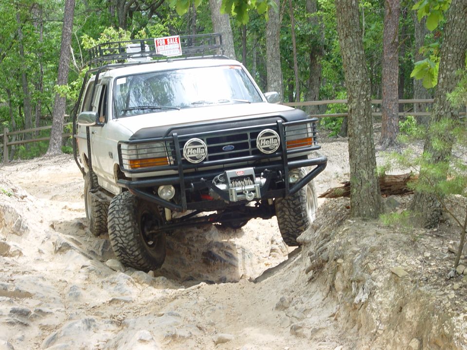 White 1996 Ford Bronco on rocky trail with FOR SALE sign