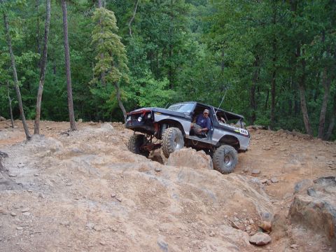 1996 Ford Bronco - This modified SUV navigates a challenging rocky terrain with a driver behind the wheel.