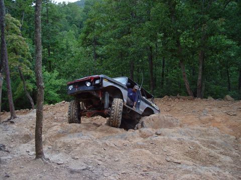 1996 Ford Bronco - A modified Ford Bronco navigates a challenging rocky terrain with a driver inside.